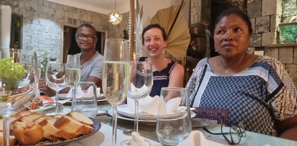 Convives souriants autour de la table dressée, verres de vin pétillant et pain frais